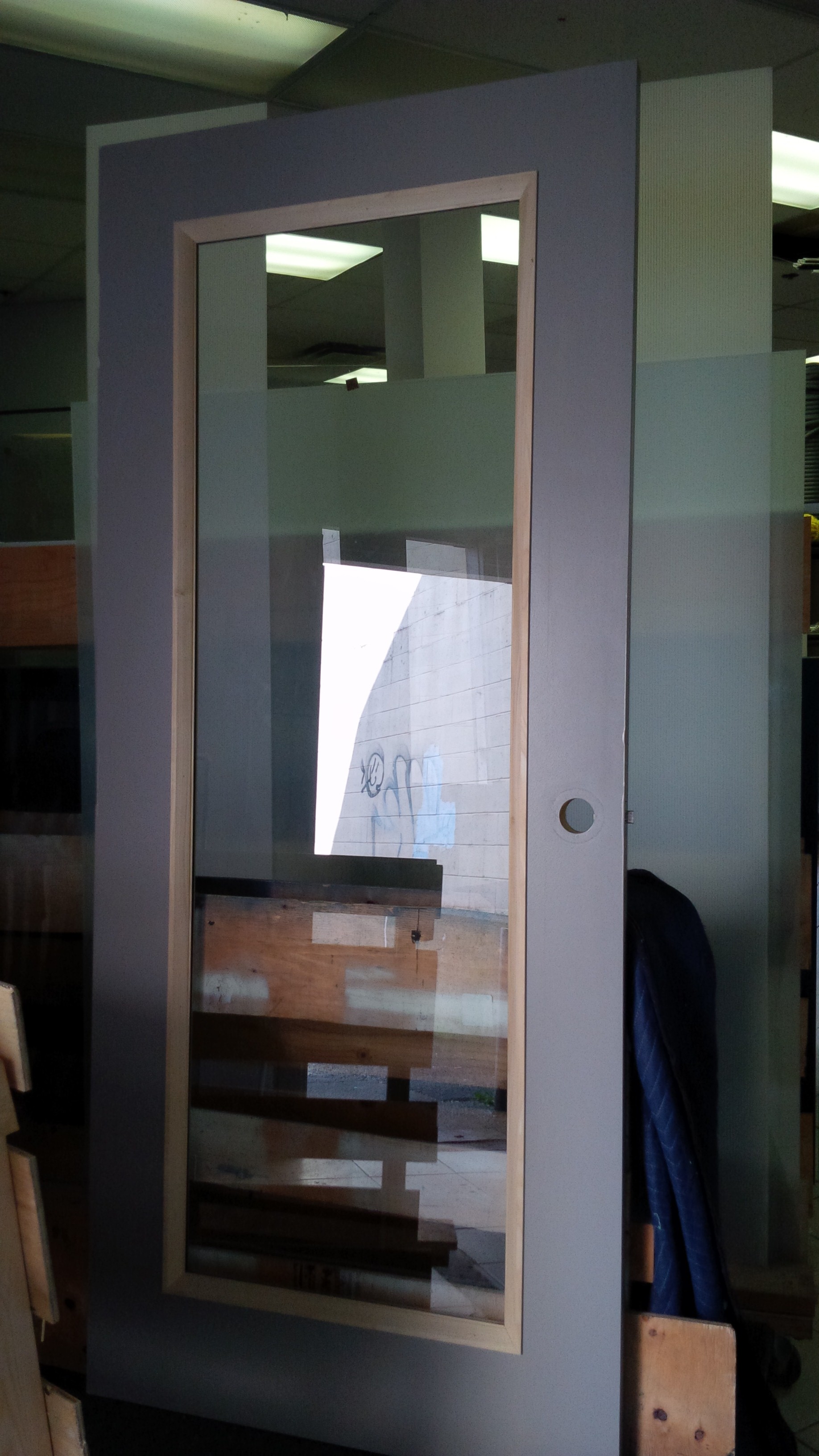 Cut open wood entry door and installed clear glass into it.
