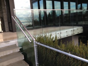 Custom glass railing system for home. This glass railing was frameless with thick safety glass. Custom bolts were used for securing glass railing to place