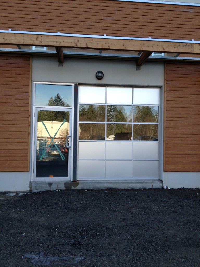 Custom-built commercial glass doors with heavy-duty industrial styling and complete door hardware installed in Langley.