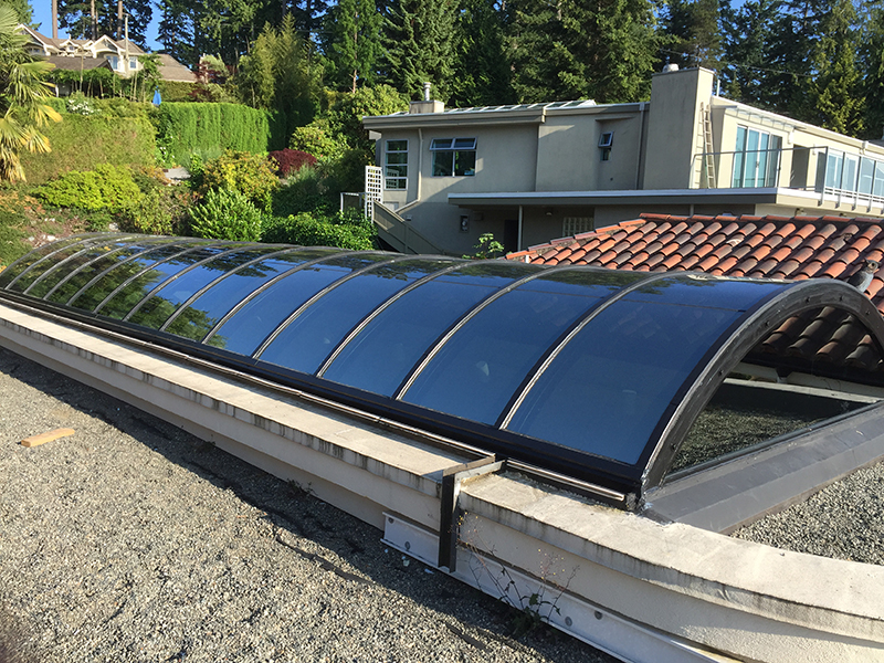 Curved skylight replacement in West Vancouver with new energy-efficient safety glass installed on an existing roof skylight system.